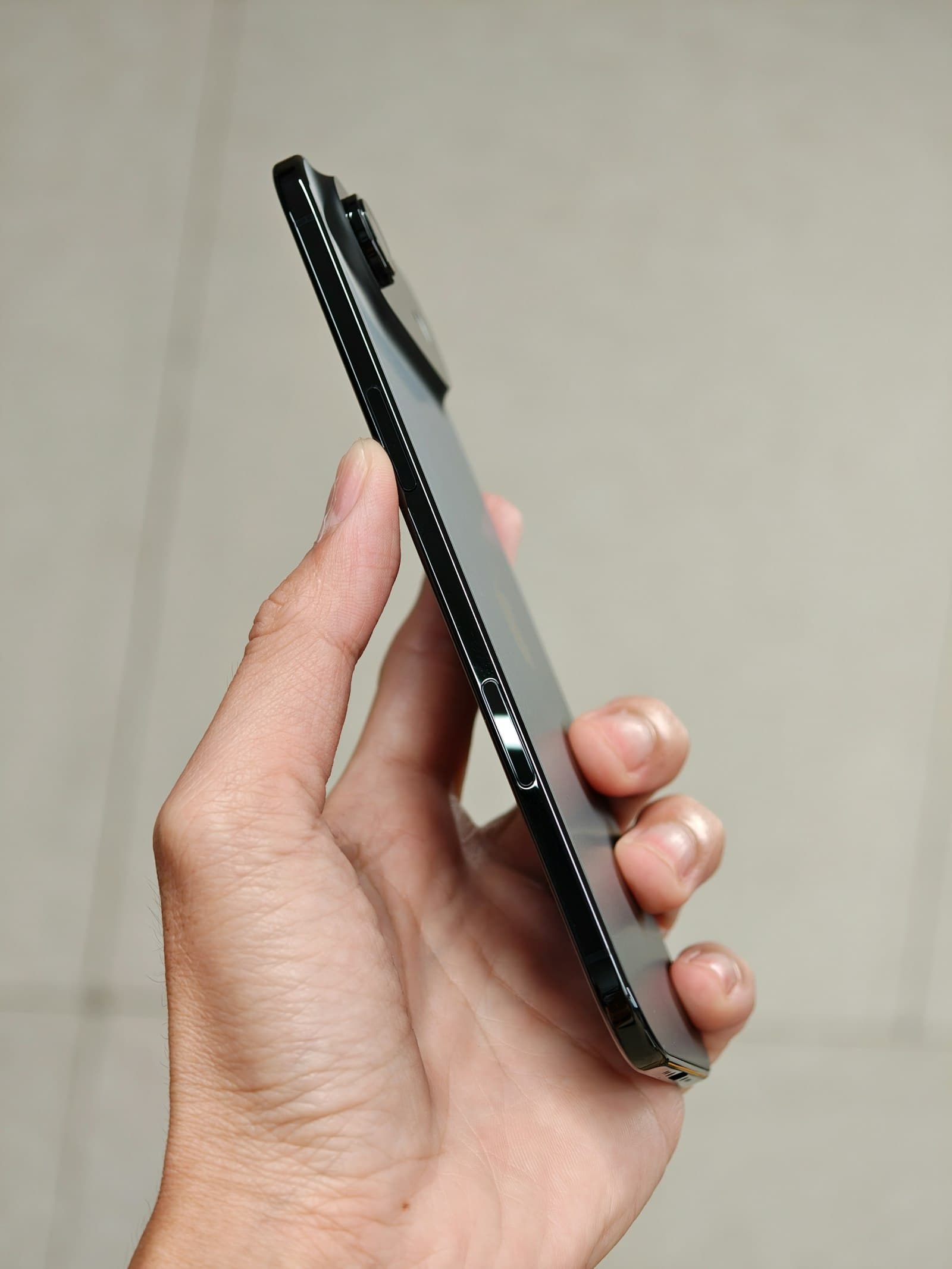 Main tenant un smartphone noir moderne de profil