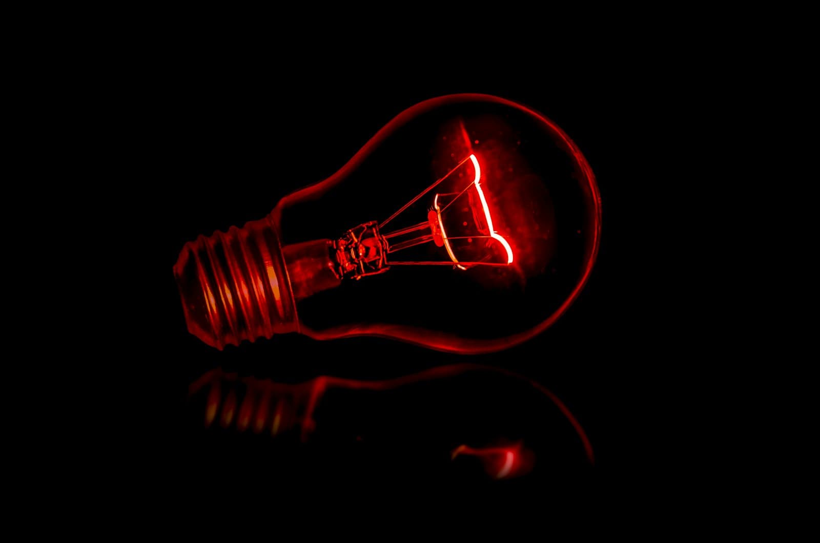 Ampoule allumée sur fond sombre symbolisant les économies d'énergie